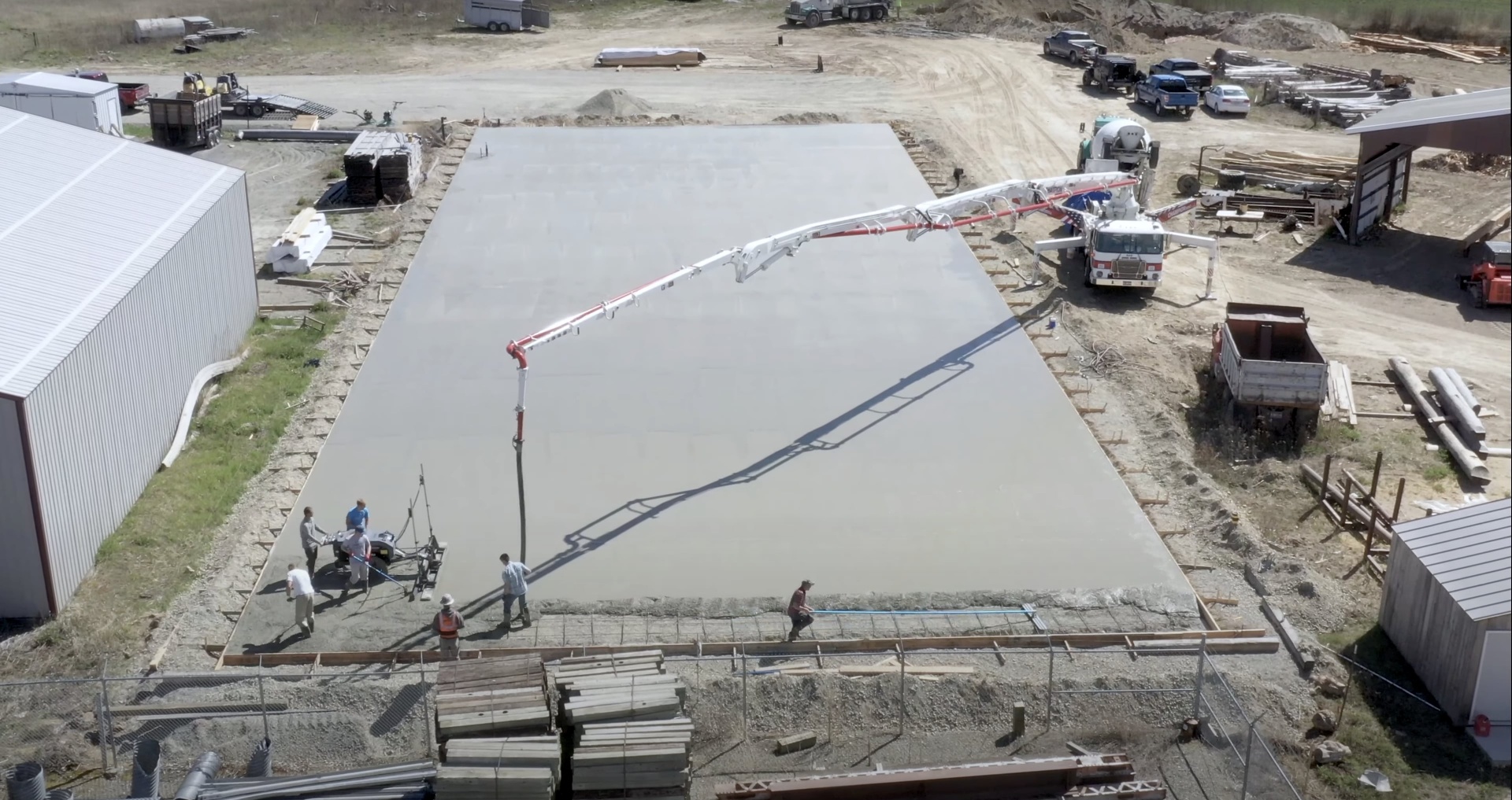 Commercial concrete slab installation in Dover, NH Aerial view of large-scale concrete slab installation with concrete pump truck and professional crew